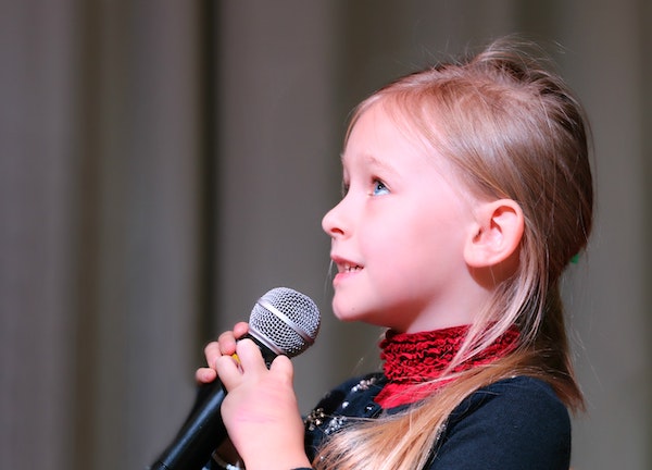 Young girl singing at loved ones funeral